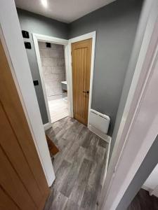 a bathroom with a hallway with a toilet and a door at Luxurious 2 Bedroom Private Detached Cottage in Llanddulas