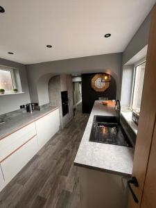 a kitchen with a sink and a counter top at Luxurious 2 Bedroom Private Detached Cottage in Llanddulas