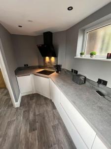 a kitchen with white cabinets and a counter top at Luxurious 2 Bedroom Private Detached Cottage in Llanddulas