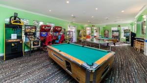 una sala de juegos con mesa de billar y máquinas recreativas en 4 BR Private Vacation Home, en Kissimmee