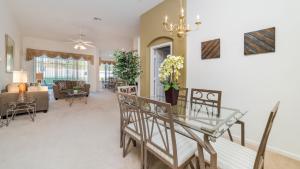 comedor y sala de estar con mesa y sillas en 4 BR Private Vacation Home, en Kissimmee