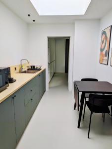 a kitchen with a table and a dining room at Spacious and cosy apartment near Berchem Station in Antwerp