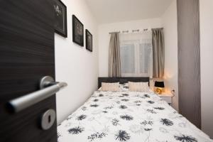 Apartment Queen - private parking في أوسييك: غرفة نوم بسرير لحاف اسود وبيض