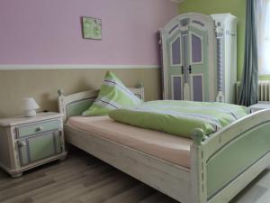 a bedroom with a white bed and a night stand at Hotel 4 Jahreszeiten mit Restaurant in Albstadt