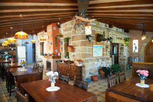 un restaurante con mesas y sillas de madera y una pared de piedra. en Posada La Capía en Vargas