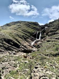 a waterfall on the side of a mountain at Pousada Mangaba da Serra in Serra do Cipo