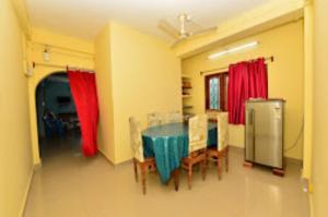 comedor con mesa, sillas y cortinas rojas en Pramod Bhawan , Port Blair, en Port Blair