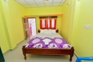 a bedroom with a bed in a yellow room at Pramod Bhawan , Port Blair in Port Blair