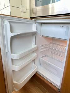 um frigorífico aberto com a sua porta aberta e as suas prateleiras em Cozy Apartment in the heart of Antwerp em Antuérpia