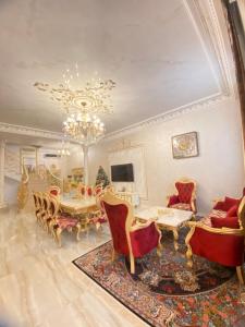 una sala da pranzo con tavolo, sedie e lampadario pendente di Baku Villa Family a Baku