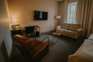 a hotel room with a bed and a chair and a desk at Coop Hotell in Jõgeva