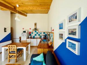 a kitchen and living room with a blue and white wall at Sea Roots "Garden Zone " in Mosteiros