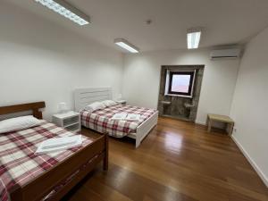 a bedroom with two beds and a window at Casa em Aldeia rural - Circuito Aldeias de Portugal in Ponte de Lima