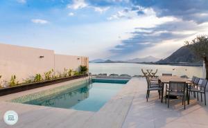 a patio with a table and chairs next to a swimming pool at Sea Breeze Villa in Fujairah