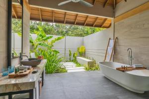 a bathroom with two sinks and a tub at Emerald Faarufushi Resort & Spa - Deluxe All Inclusive in Raa Atoll