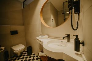 a bathroom with a sink and a mirror and a toilet at Coop Hotell in Jõgeva