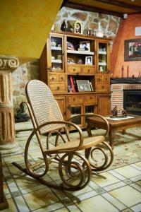 a rocking chair in a room with a fireplace at Posada La Capía in Vargas
