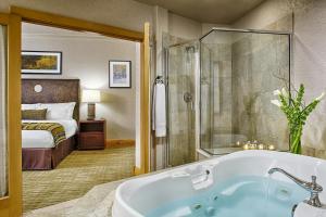 a bathroom with a tub and a bedroom with a bed at Fairmont Heritage Place, Franz Klammer Lodge in Telluride