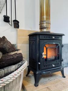 a black stove in a room next to a couch at Sea Roots "Garden Zone " in Mosteiros