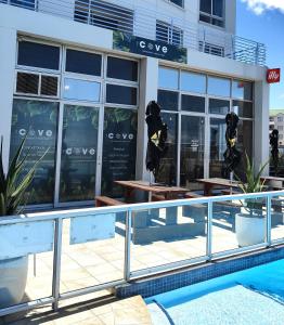 a building with tables and benches in front of it at Tranquil Impulse on Strand in Cape Town