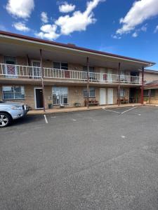 un edificio con un coche aparcado delante de él en OVERLANDER MOTOR LODGE, en Gunnedah