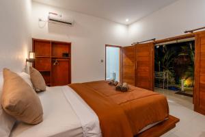 una camera con un grande letto e una finestra di Villa Doria formerly Rangga Homestay a Gili Air
