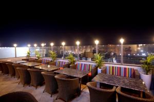 Mohali的住宿－Hiraya Hotels，夜晚屋顶上一排桌椅