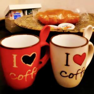 dos tazas de café con corazones en ellas sentadas en una mesa en Affection Apartment, en Bolonia