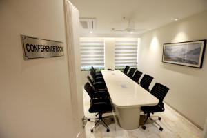 una sala de conferencias con una mesa blanca y sillas negras en Hiraya Hotels en Mohali