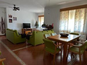 un soggiorno con tavolo e sedie verdi di La casa barata, casa rural a Cedillo