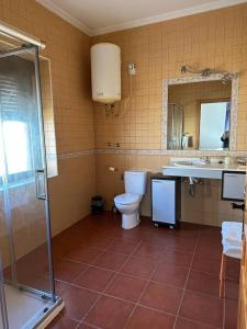 a bathroom with a toilet and a sink and a shower at La casa barata, casa rural in Cedillo