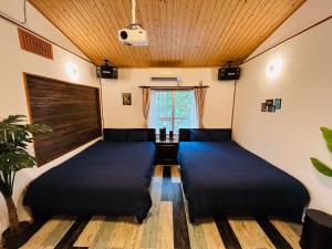 Habitación con 2 camas y ventana en Lodge Crea, en Ujimi
