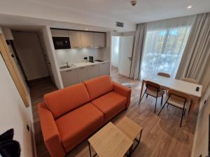 uma sala de estar com um sofá laranja e uma mesa em Appart'hôtel Marianne em Montpellier