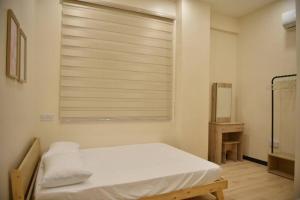 - une chambre avec un lit et une fenêtre avec des stores dans l'établissement Your home away from home., à Sandakan