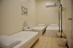 Cette chambre comprend 2 lits, un lavabo et un miroir. dans l'établissement Your home away from home., à Sandakan