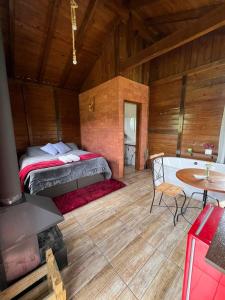 a bedroom with a bed and a table in a room at Chalé na Serra Urubici in Urubici