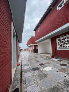 an empty alley between two buildings with a red building at Hostal Del Sol Temporario in Rosario