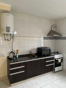 uma cozinha com um lavatório e um micro-ondas em Hostal Del Sol Temporario em Rosário