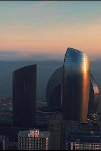 un grupo de edificios en una ciudad al atardecer en Access Hotel en Baku