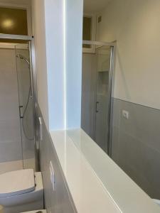 a white bathroom with a shower and a toilet at Gioberti 25 in Alghero