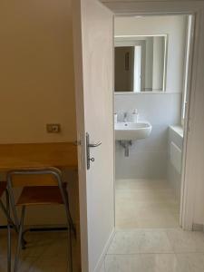 uma casa de banho com um lavatório, um espelho e uma cadeira em Gioberti 25 em Alghero