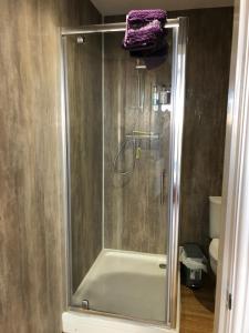 a shower with a glass door in a bathroom at Rolling Mill, Wolds Way Holiday Cottages, 2 Bed, 1st floor in Cottingham