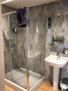 ein Bad mit einer Dusche und einem Waschbecken in der Unterkunft Rolling Mill, Wolds Way Holiday Cottages, 2 Bed, 1st floor in Cottingham