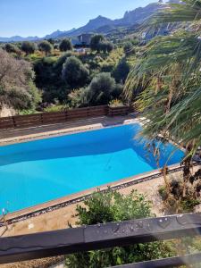 凱里尼亞的住宿－Villa Ravine - 4 Bedroom Villa，一座蓝色的游泳池,后面是一座山