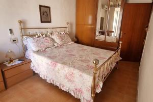 1 dormitorio con 1 cama grande y espejo en La casa di nonna Ivola, en Tocco da Casauria