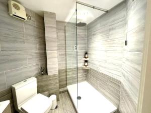 a bathroom with a toilet and a shower at Rooms Near Me - Walsall City Centre Apartment in Walsall