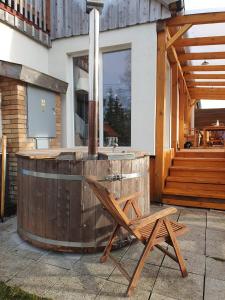 a wooden tub with a chair next to a building at Chalupa Pasečná in Přední Výtoň