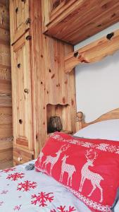 a bedroom with a bed with a red blanket with reindeers at Le Banc Des Seilles in Bonvillard