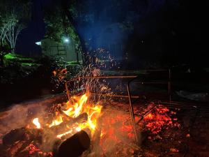 un fuego arde en un patio por la noche en Witrivier Farmstay Self-Catering, en Cambria