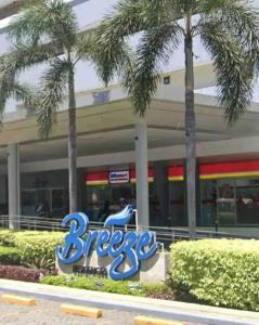 a sign for a grocery store with palm trees in front at Smdc Breeze Residence in Manila